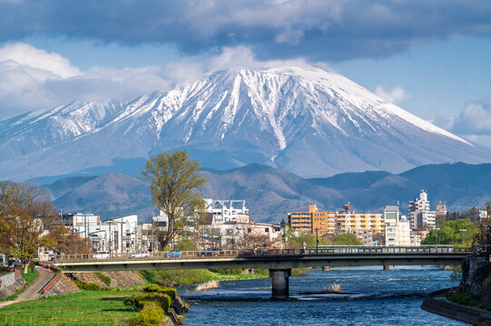 Buildings and promenade and riverside walkway at Katakami riverflowing through the middle of Morioka city, Iwate Cityscape  with Iwate Mount Background scene in Morioka,  Iwate, Japan