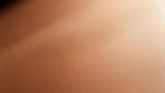 Smooth bronzed warm skin texture close up with soft diagonal light and intimate warm lighting