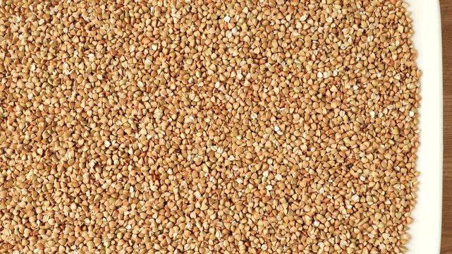 Raw buckwheat grains rotating in a circle as a healthy food ingredient for cooking porridge.