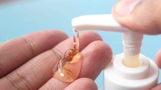 Hand pump dispensing liquid soap or sanitizer onto palm for hygiene and cleanliness