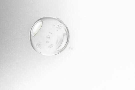 A large, clear soap bubble with smaller ones, against a solid black background