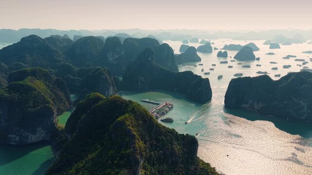 Aerial view of Halong bay with tour cruise boats between limestone islets sunset time, tourist landmark of Vietnam.