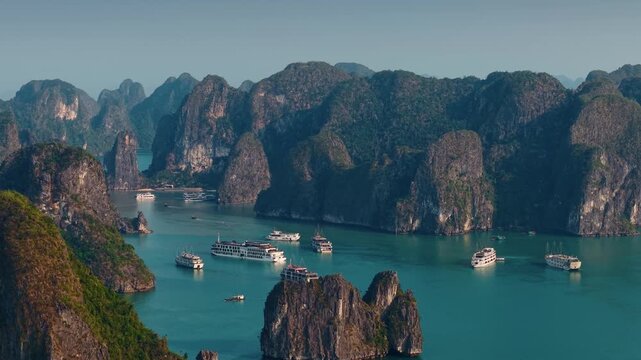 Aerial view breathtaking sunset over Halong bay's limestone karsts and serene waters, tour cruise boats.