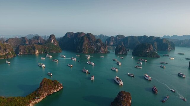 Aerial view of Halong bay with tour cruise boats between limestone islets sunset time, tourist landmark of Vietnam.