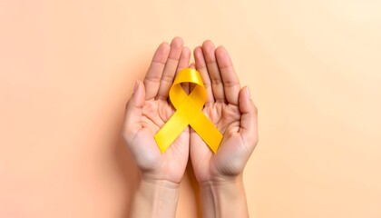 Hands holding a yellow ribbon against a light orange background