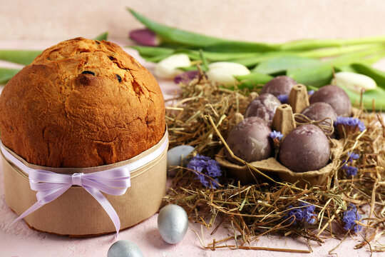 Delicious Easter cake with painted eggs and tulip flowers on beige background