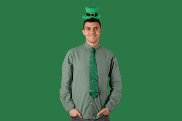 Happy young man on green background. St. Patrick's Day