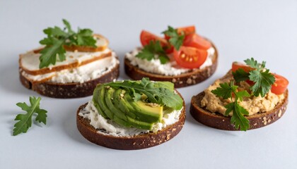 Four Open-faced Sandwiches with Avocado, Tomato, and Smoked Meat Toppings on Dark Bread