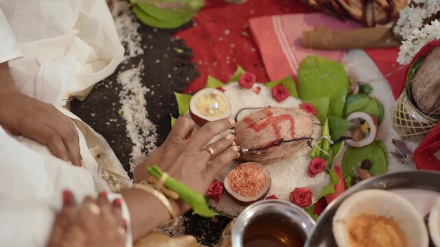 Cinematic close-up of a sacred Hindu wedding ritual featuring a coconut with a red swastika, betel leaves, and rice, capturing authentic Indian matrimonial traditions and holy puja offerings.