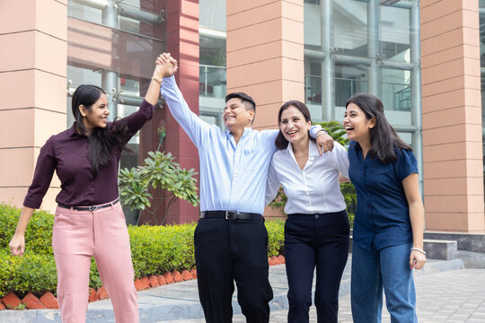 Happy young indian entrepreneur, office employees having fun in break time outdoors, Teamwork and unity, Business and finance.