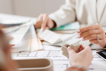 Presentation of design interior, Female designer with client discussing color samples and 3d models at work desk