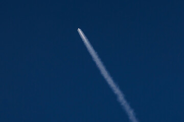 Rocket launches into clear blue sky leaving white trail, concept aerospace program