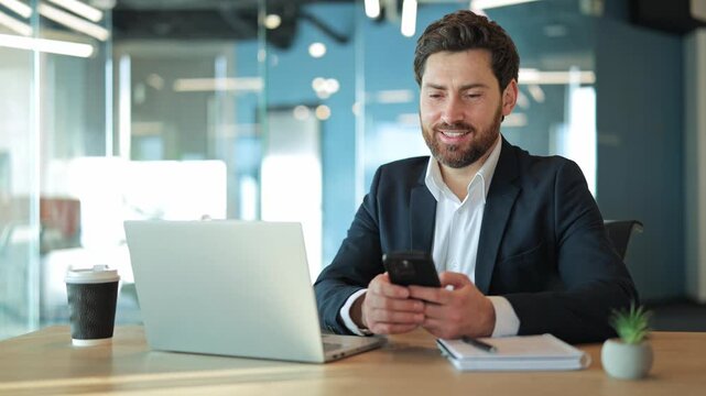 Business professional finds joy using smartphone at modern office desk. Expresses happiness and satisfaction while engaged with technology. Communication, productivity, success bright clean workspace.