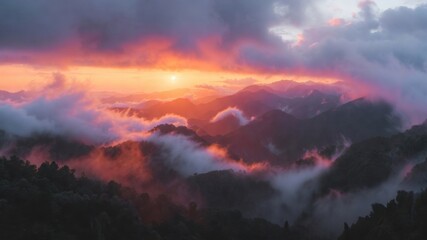 Stunning mountain sunrise with vibrant clouds and misty peaks.