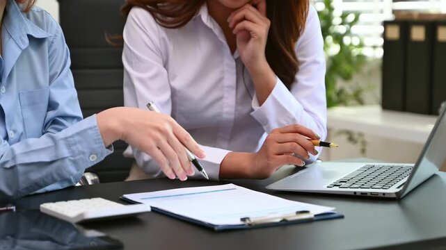 Businesswoman and team analyzing financial statement Finance task. with smart phone and laptop and tablet.