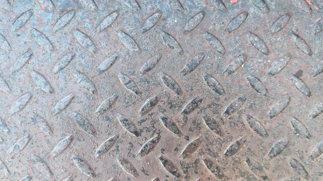 Video of weathered steel diamond plate texture with rust, rough industrial metal surface.