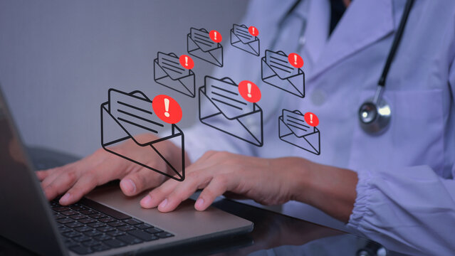 Medical doctor worried about spam mail hacking hospital information system security while looking at laptop screen warning about data breach
