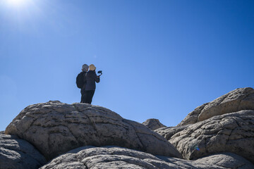 Couple taking photos at White Pocket. Vermilion Cliffs National Monument. Arizona. USA.