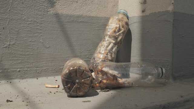 Cigarette butts in bottles create a dirty and disgusting mess.