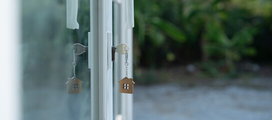 Landlord key for unlocking house is plugged into the door. Second hand house for rent and sale. keychain is blowing in the wind. mortgage for new home, buy, sell, renovate, investment, owner, estate