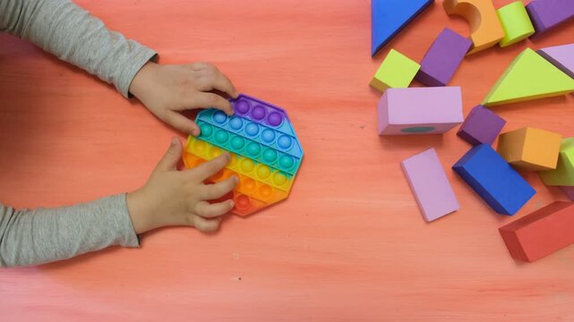 Child playing with silicone toy antistress. Trendy antistress sensory toy fidget push. Alternative therapy. ADHD
