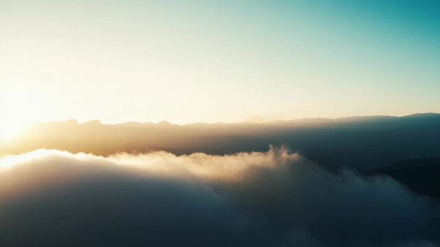 Soft golden sunlight filters through a vast sea of clouds draping rolling mountain peaks, creating a serene, ethereal dawn or dusk vista with misty, peaceful atmosphere