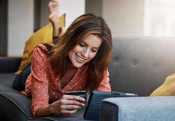 Obraz premium Happy woman, tablet or online shopping with credit card for payment or purchase on sofa in home. Female person, shopper or smile with debit or technology for ecommerce or virtual banking app in house