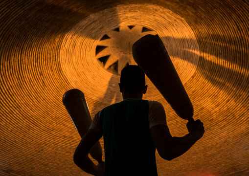 Iranian man wielding wooden clubs during the traditional sport of zurkhaneh, Yazd province, Yazd, Iran