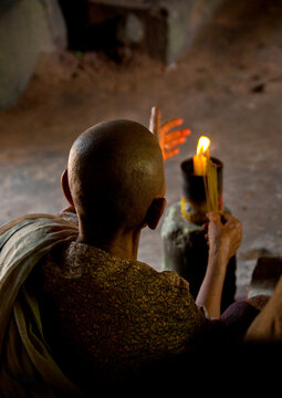 Female monk with a candle praying in a tempe in Angkor wat, Siem Reap Province, Angkor, Cambodia