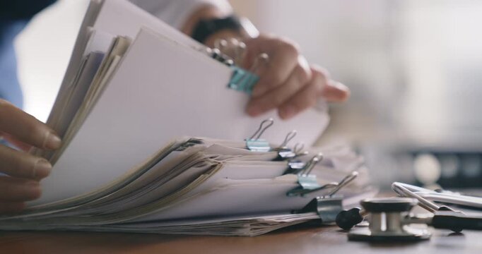 Healthcare personnel reviewing a stack of files