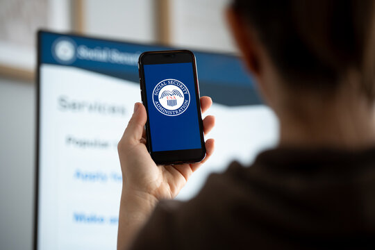 United States Social Security Administration SSA logo sign on a smartphone, website in bg. Federal insurance program providing retirement, disability, benefits on February 17, 2026 in Krakow, Poland.