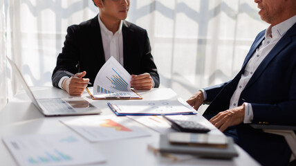 diverse coworkers working together in boardroom, brainstorming, discussing and analyzing and planning business strategy.
