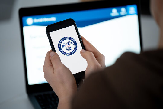 United States Social Security Administration SSA logo sign on a smartphone, website in bg. Federal insurance program providing retirement, disability, benefits on February 17, 2026 in Krakow, Poland.