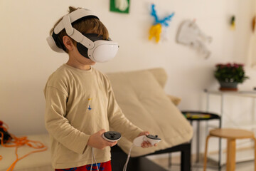 Young boy playing a virtual reality game at home