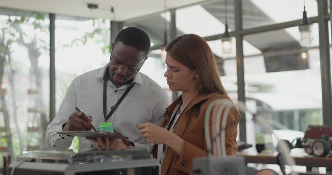 A diverse team of startup professionals collaborates on a 3D printing project in a modern workspace. Highlighting innovation, teamwork, and the prototyping process in a creative tech environment.

