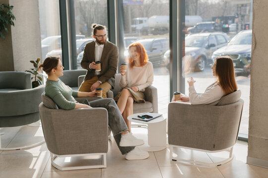 Business colleagues having informal meeting in modern office lobby