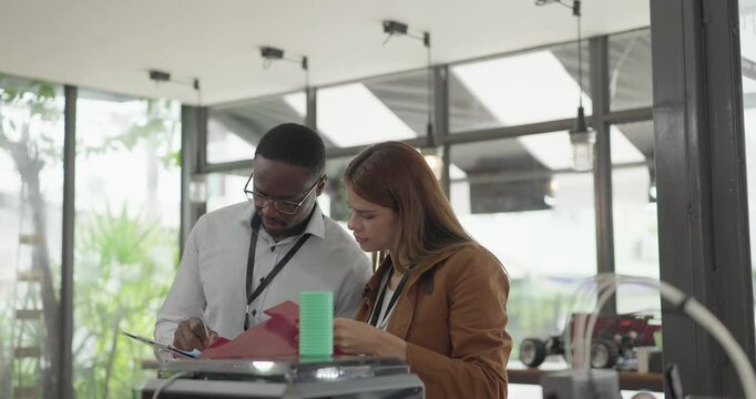 A diverse team of startup professionals collaborates on a 3D printing project in a modern workspace. Highlighting innovation, teamwork, and the prototyping process in a creative tech environment.
