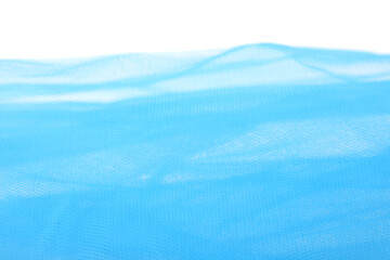 Bright blue tulle fabric background.  Abstract transparent material curve wave.