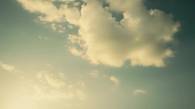 Soft cumulus clouds drift across a vintage tinged blue sky, offering a calm, airy backdrop with warm tones and dreamy sunlightideal for serene, open space designs