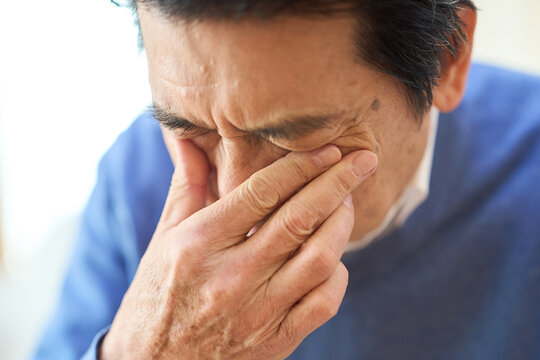 目に異常を感じるアジア人シニア男性