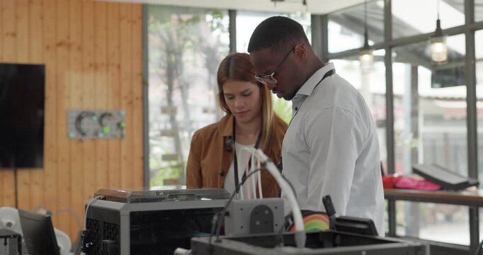A diverse team of startup professionals collaborates on a 3D printing project in a modern workspace. Highlighting innovation, teamwork, and the prototyping process in a creative tech environment.
