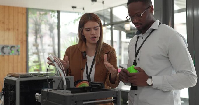 A diverse team of startup professionals collaborates on a 3D printing project in a modern workspace. Highlighting innovation, teamwork, and the prototyping process in a creative tech environment.
