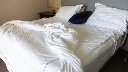 Messy White Bed in a Hotel Room