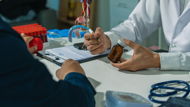 The doctor and patient are discussing prostate examinations, providing advice and explanations to a testicular cancer patient in the examination room, using a model of the male genitalia.