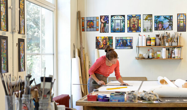 Woman working on draft in glazier's workshop