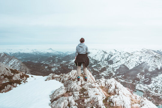 Back view of young woman standing on mountain top looking at view, Leon Province, Spain