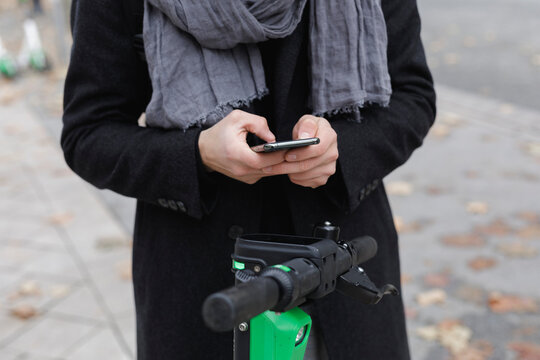 Crop view of man scanning QR Code for activating rental electric scooter