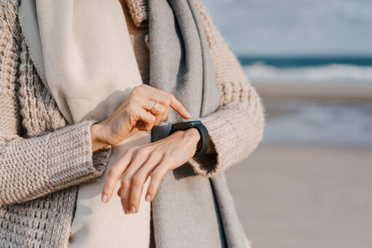 Woman on the beach checking her smartwatch