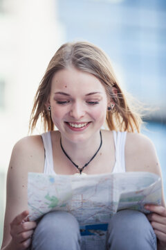 Young girl traveling alone, looking at map