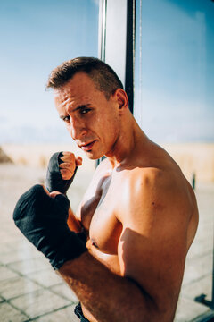 Portrait of boxer wearing bandages at the window